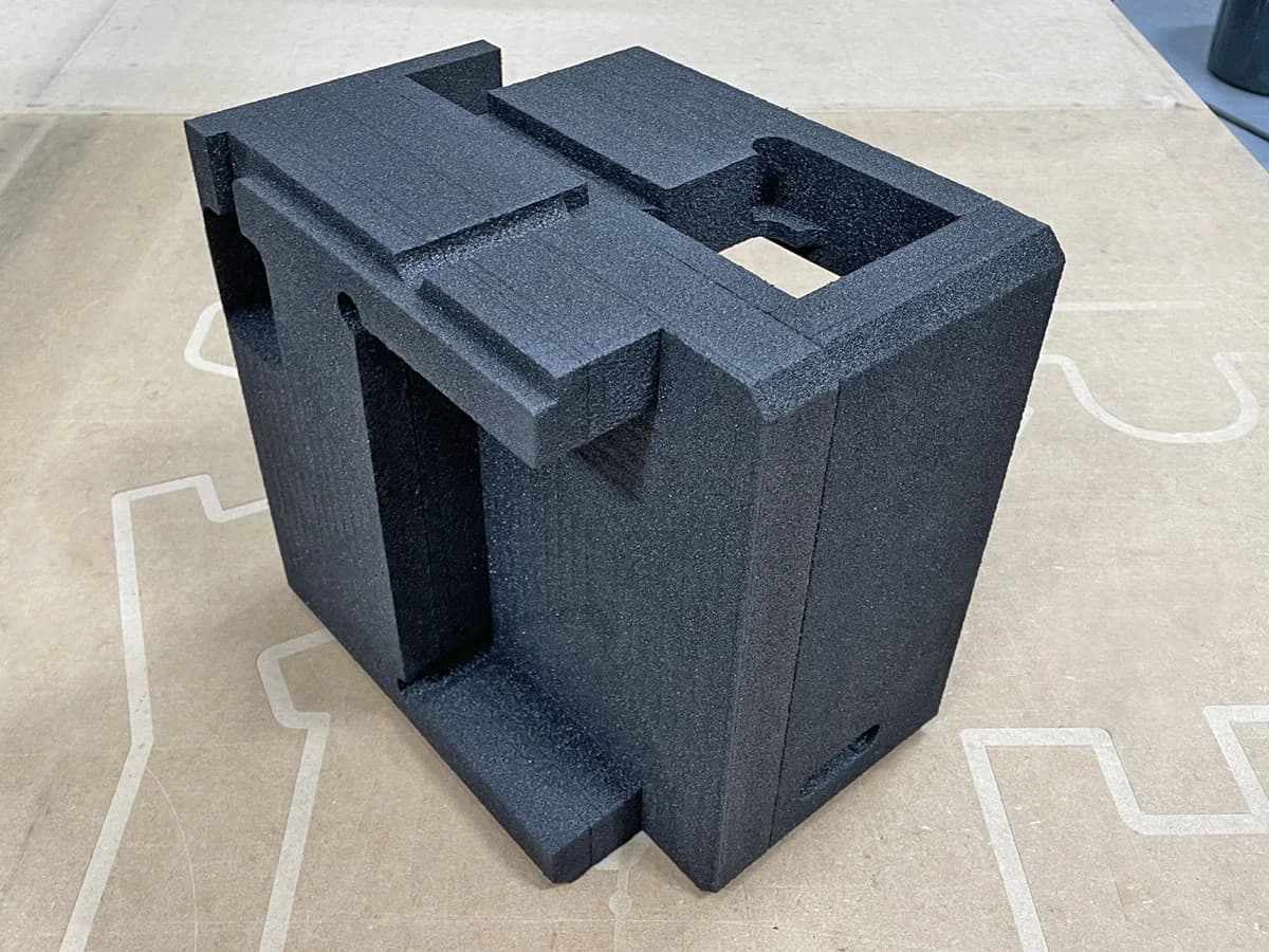 Custom cut black foam packaging block with shaped cavities