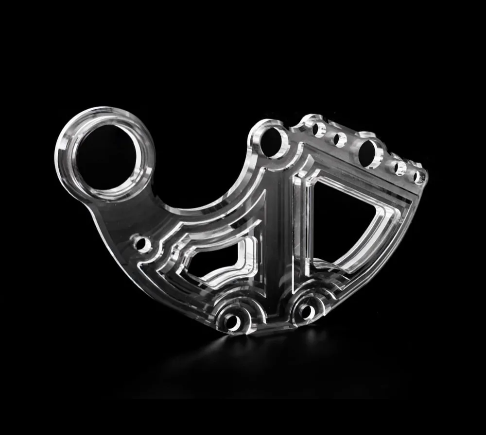 Clear machined plastic part on a black background