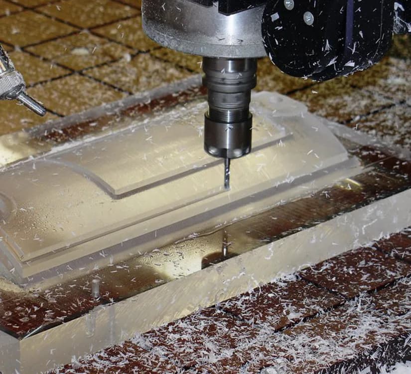 CNC routing a plastic sheet with visible shavings