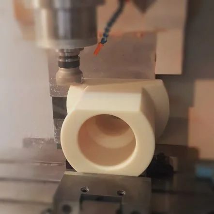 CNC machining a beige plastic bushing component